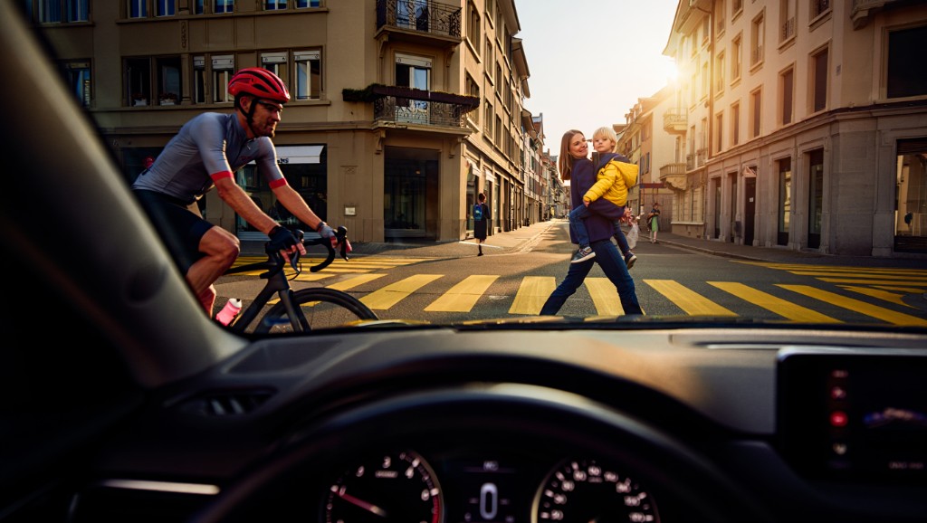 Driver view at Swiss zebra crossing with cyclist and pedestrians — hazard perception
