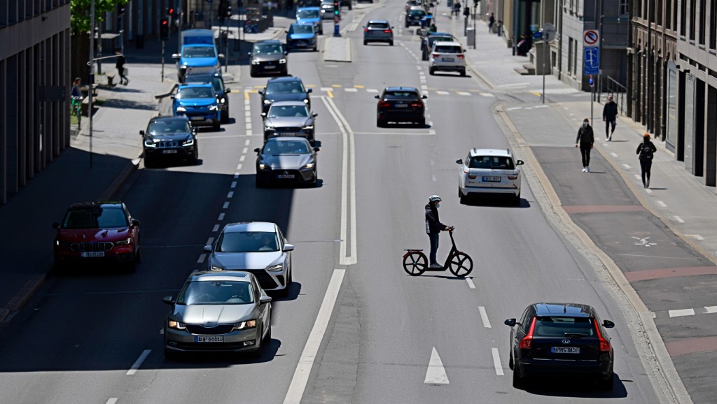 Urban Swiss street with cars and e-scooter — road sharing and multimodal traffic