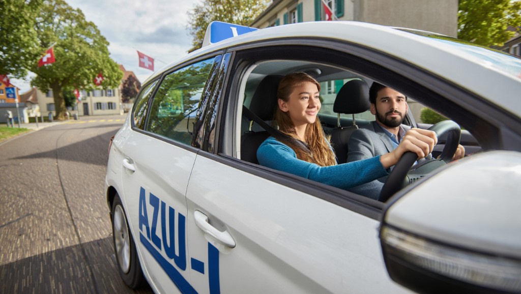 Driving lesson in a Swiss town — learner vehicle with L plate and AZUL branding